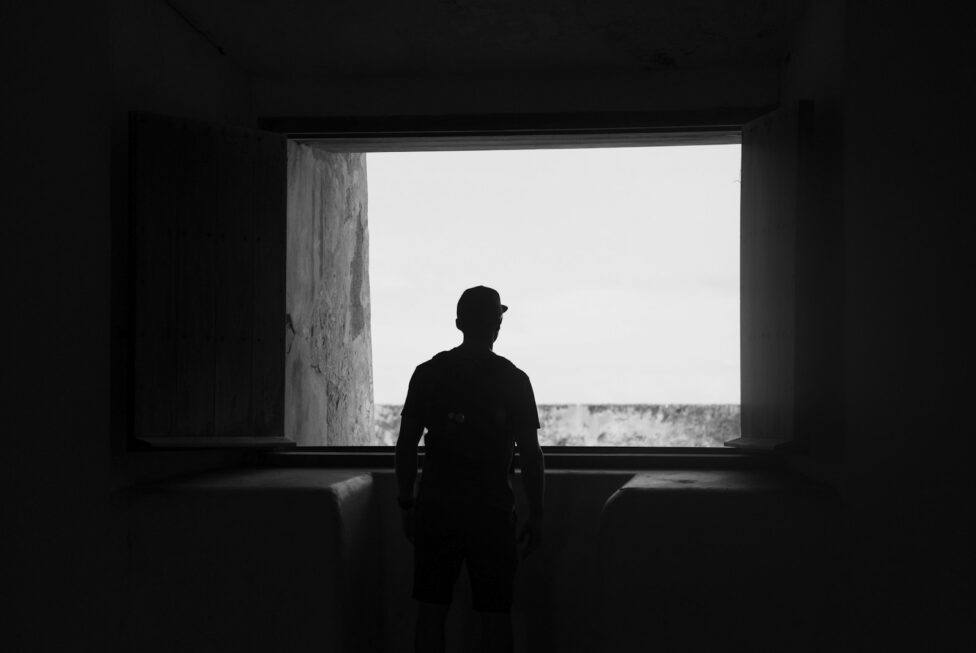silhouette of man standing near window